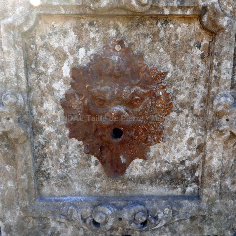 Fontaine murale - une belle fontaine de jardin avec sa sortie d'eau en fonte.