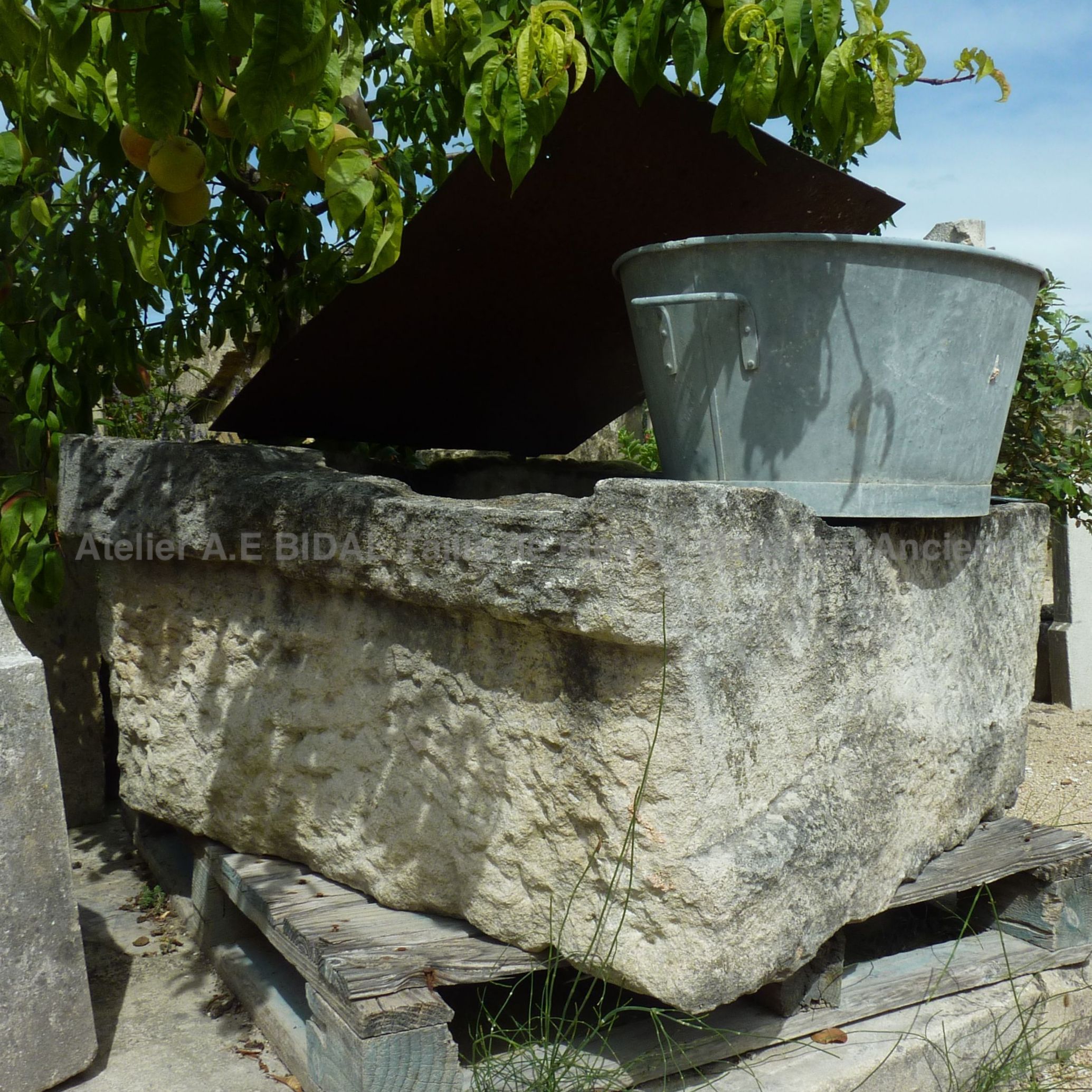 Puits ancien en pierre calcaire avec couvercle.