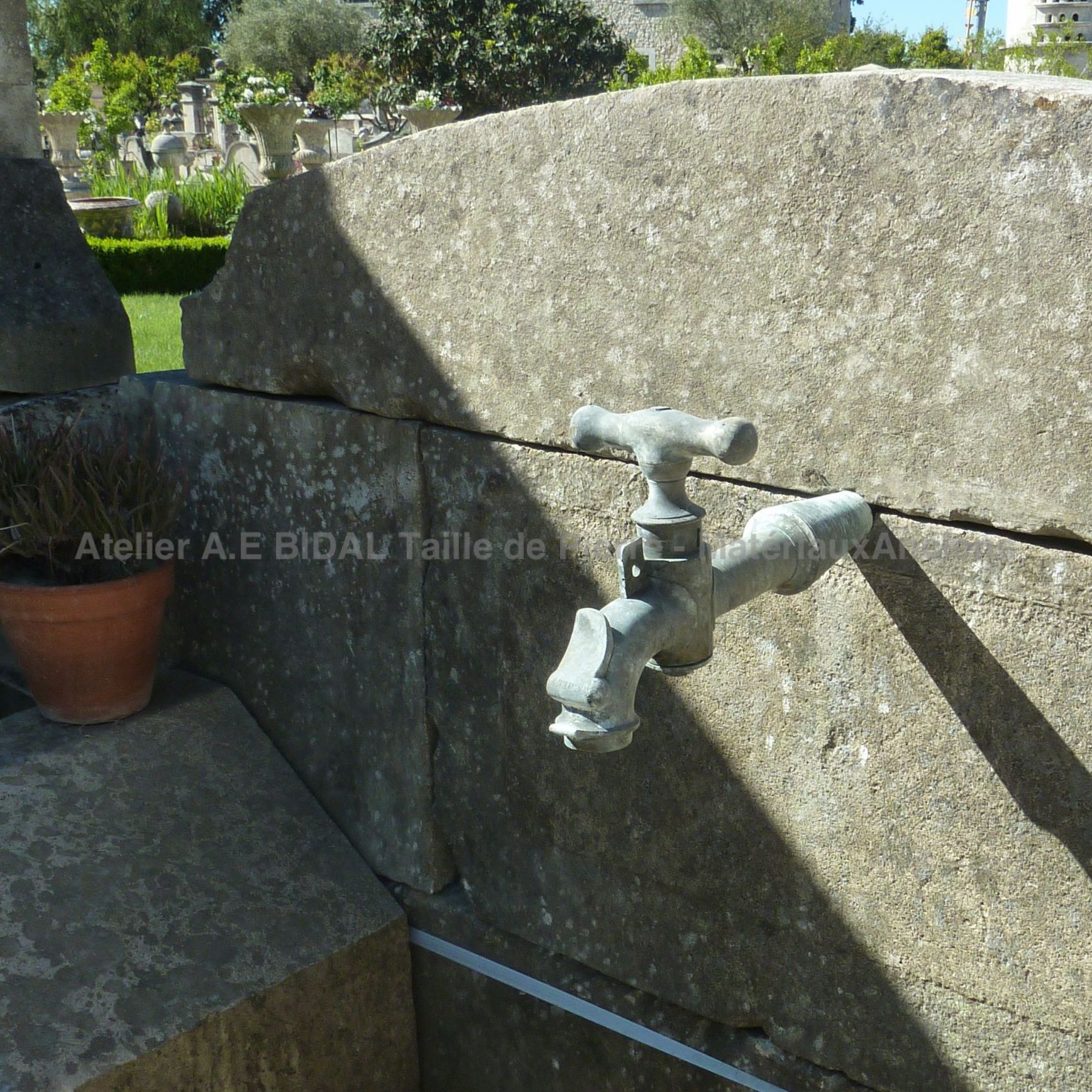 Ancien robinet en métal sur notre fontaine d'extérieur avec bassin de type lavoir.