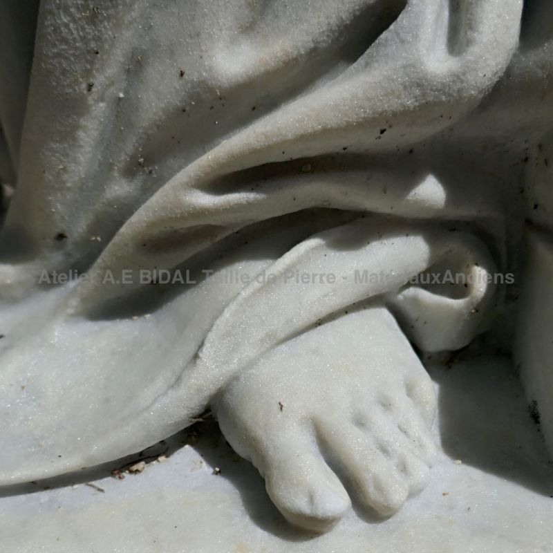 Photo de détail d'un pied sur notre statue de pleureuse sculpté en marbre blanc.