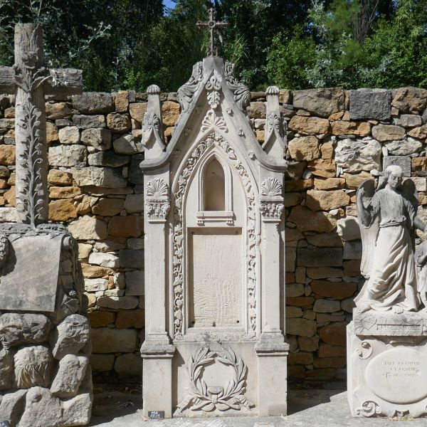 Magnificiant ornamental stele with wrought iron cross at its top.