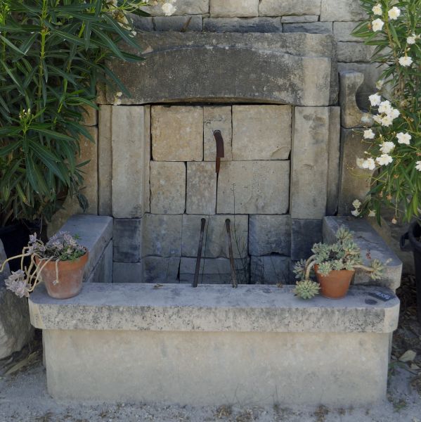 Wall fountain made of authentic old stone and wrought iron - ornamental fountain naturally weathered.