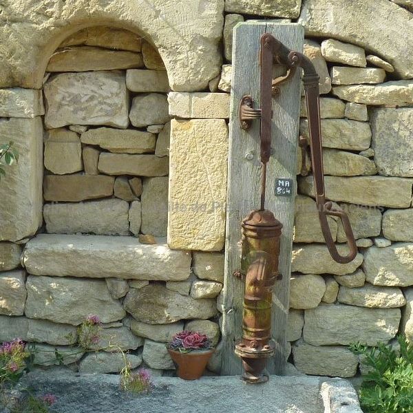 Une pompe manuelle pompe à eau avec bras en fonte ancienne marron.