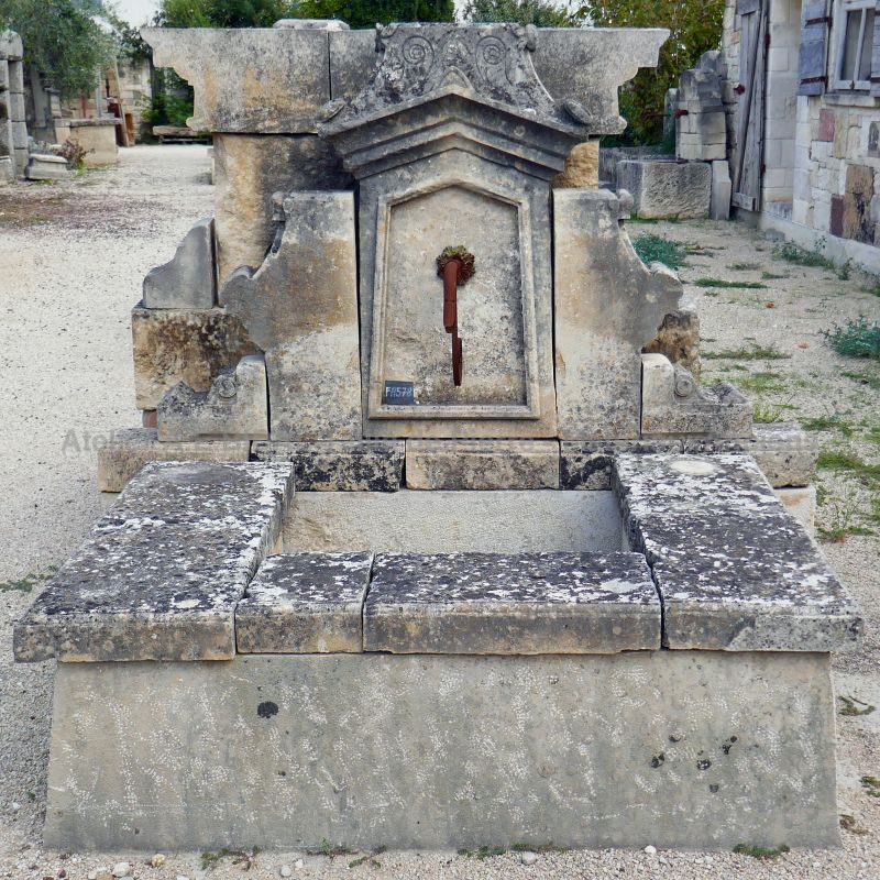 Wall fountain in a garden fountain style with basin and an authentic old pediment skillfully sculpted.