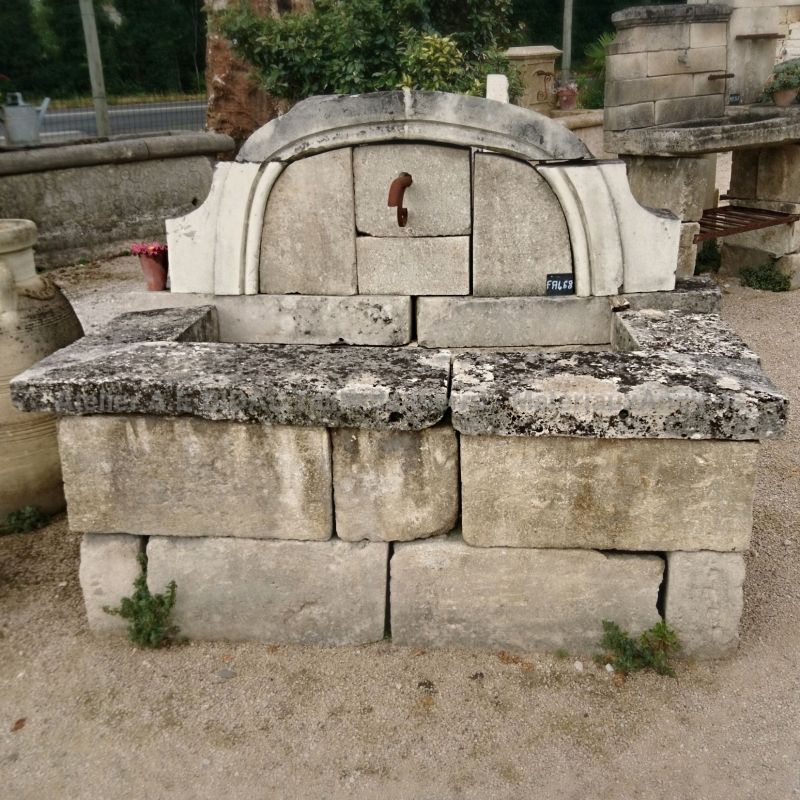 Large wall fountain with an arched pediment and high basin.