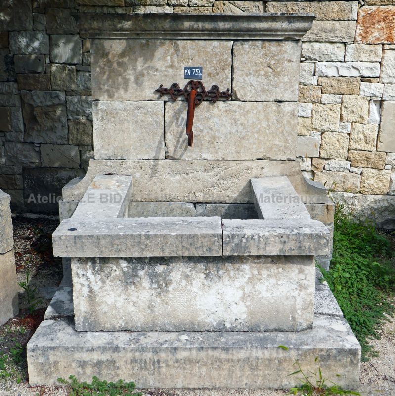 Petite fontaine en pierre - une fontaine d'extérieur avec bac et fronton (fontaine murale).